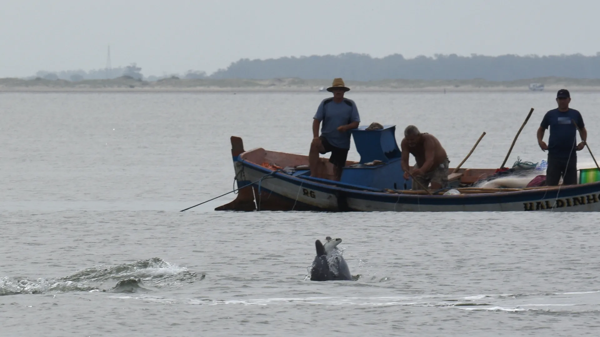 Pescadores acompanhando botos