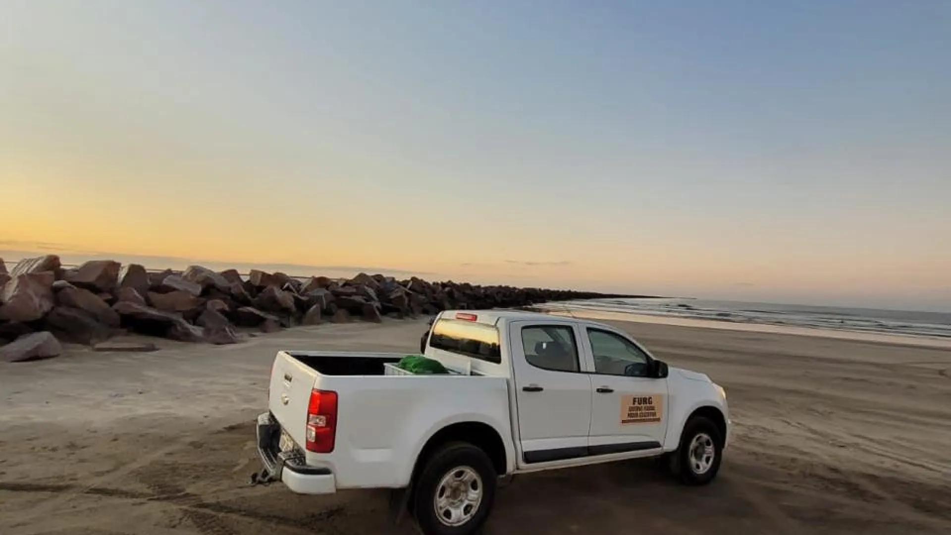 Caminhonete do Projeto Gephyreus em uma praia ao nascer do sol